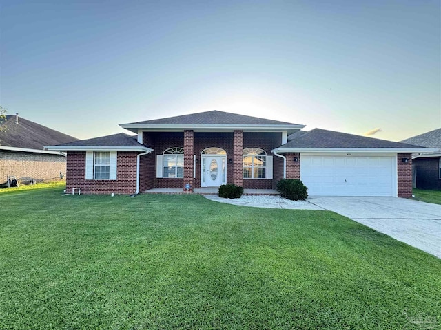 ranch-style home featuring a garage and a yard