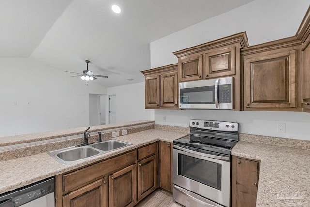 kitchen featuring ceiling fan, lofted ceiling, stainless steel appliances, and sink