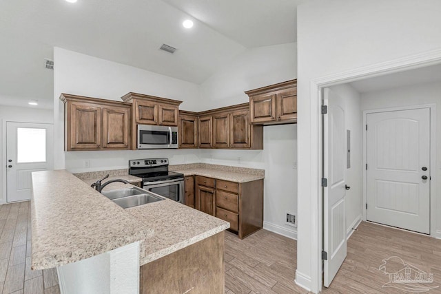 kitchen with sink, high vaulted ceiling, light wood-type flooring, kitchen peninsula, and stainless steel appliances