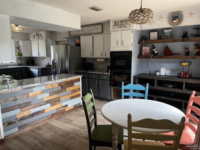 dining room with light hardwood / wood-style flooring and a textured ceiling