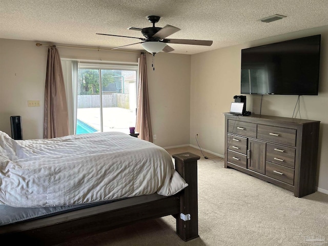 bedroom with a textured ceiling, light colored carpet, access to exterior, and ceiling fan