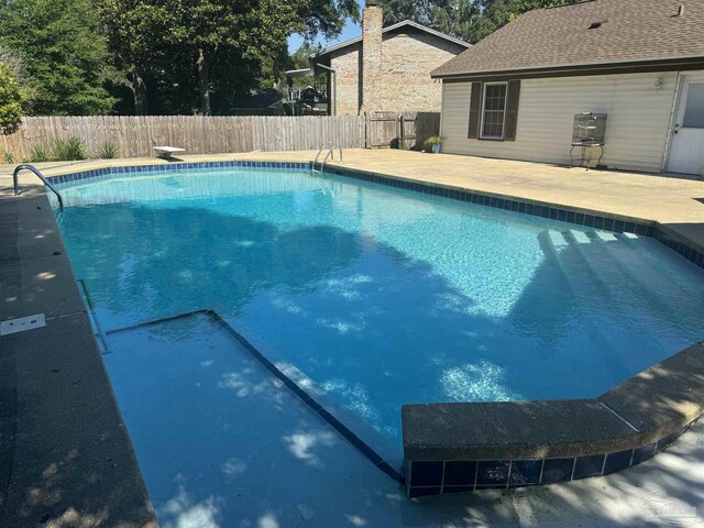 view of swimming pool with a diving board