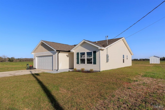 view of front of home featuring driveway, a shingled roof, an attached garage, a storage unit, and a front yard