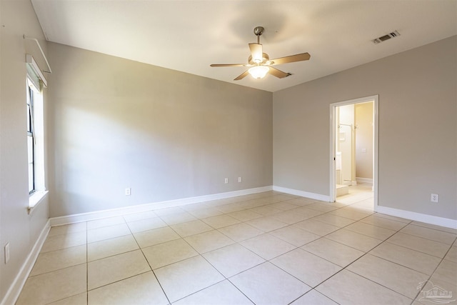 tiled spare room featuring ceiling fan