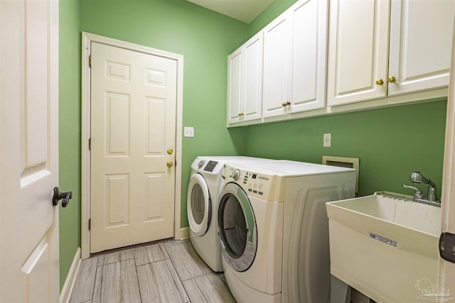 laundry room with cabinets, sink, and washing machine and dryer