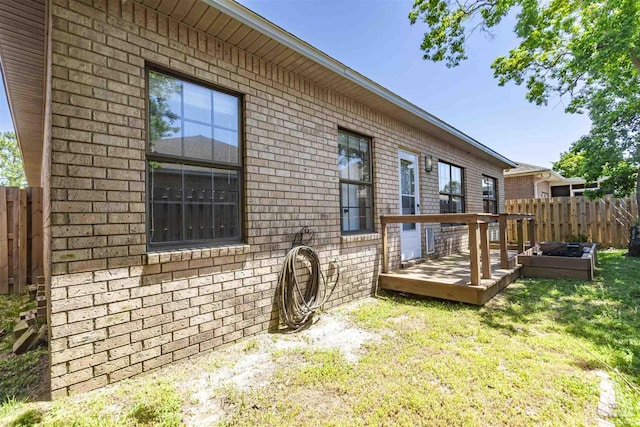 view of home's exterior featuring a wooden deck and a lawn