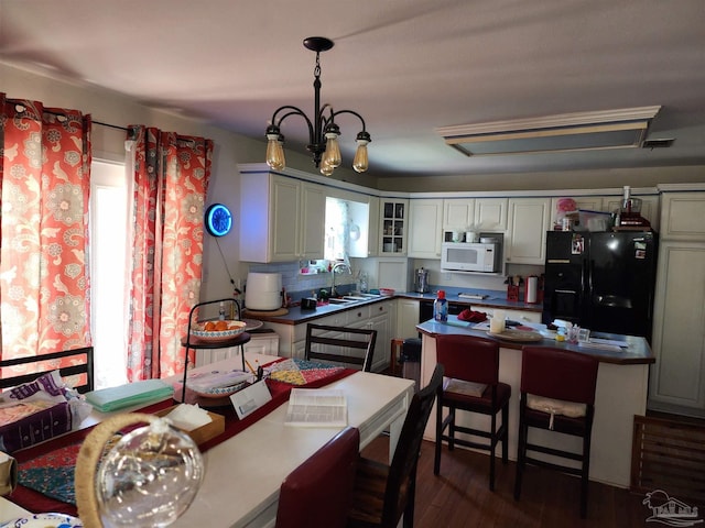 8176 Camelford Dr, Pensacola, FL 32506 - kitchen featuring black fridge, a sink, dark wood-style floors, glass insert cabinets, and white microwave