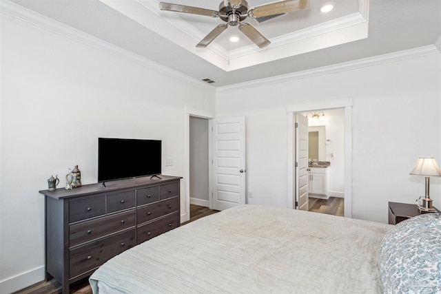 bedroom featuring a raised ceiling, crown molding, and wood finished floors