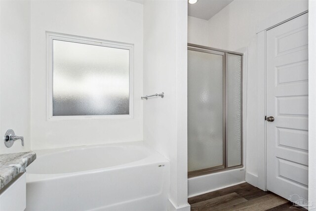 bathroom featuring shower with separate bathtub, hardwood / wood-style flooring, and vanity