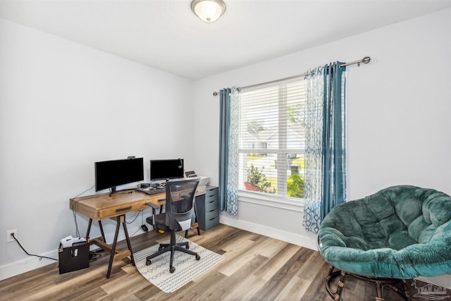 office space with a wealth of natural light, baseboards, and light wood finished floors