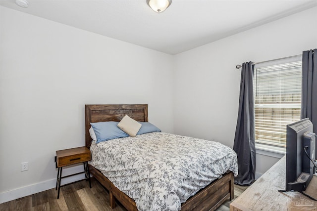 bedroom featuring baseboards and wood finished floors