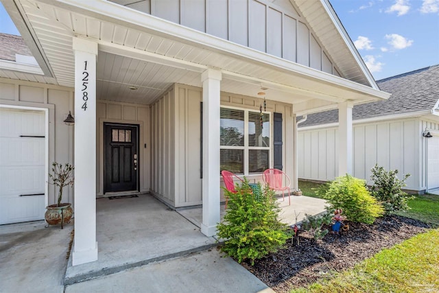 property entrance featuring board and batten siding, roof with shingles, a porch, and a garage