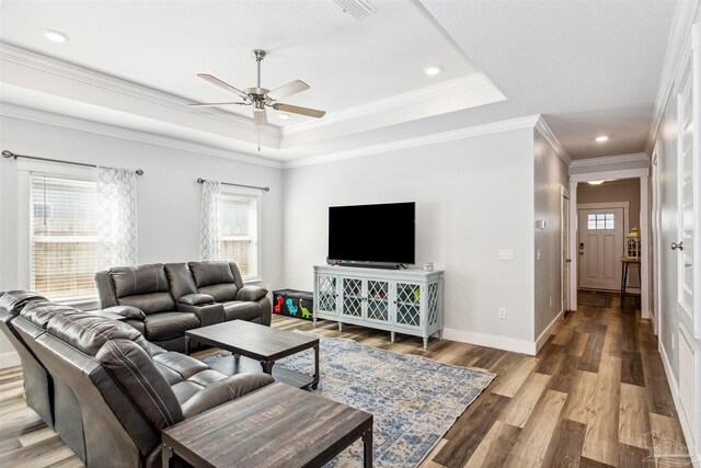 living room featuring ornamental molding, a tray ceiling, ceiling fan, and hardwood / wood-style floors