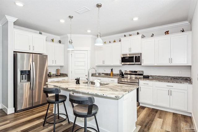 kitchen with dark wood-style floors, stainless steel appliances, ornamental molding, white cabinets, and a sink