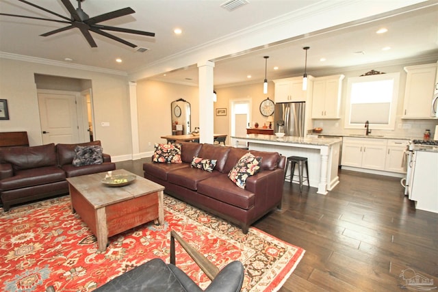 living room with dark hardwood / wood-style floors, ceiling fan, ornamental molding, and sink