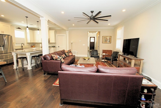 living room with crown molding, ceiling fan, and dark wood-type flooring