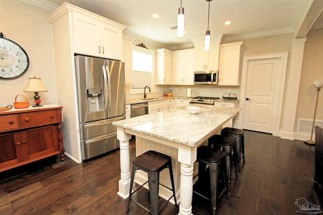 kitchen with white cabinets, appliances with stainless steel finishes, dark wood-type flooring, and pendant lighting