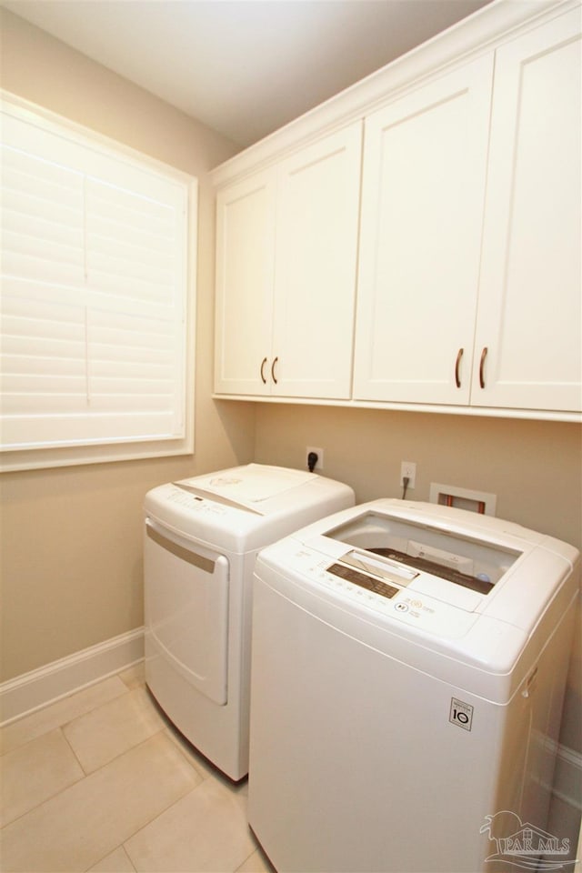 washroom featuring cabinets, independent washer and dryer, and light tile patterned floors