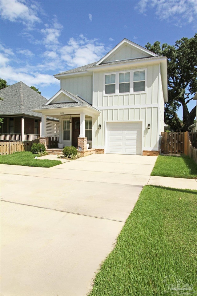 view of front facade with a porch, a garage, and a front lawn