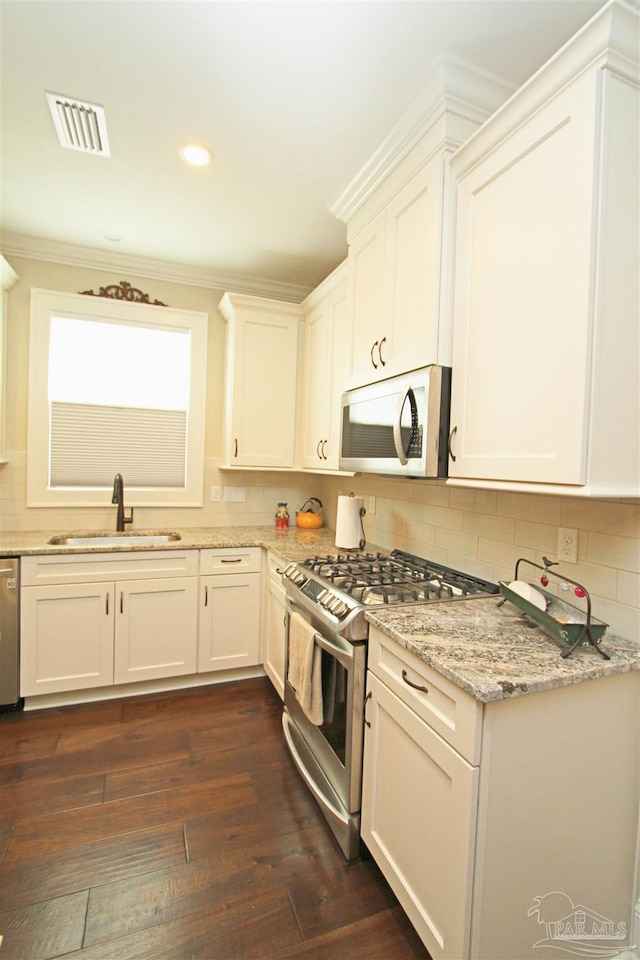 kitchen with white cabinetry, sink, stainless steel appliances, light stone counters, and dark hardwood / wood-style flooring