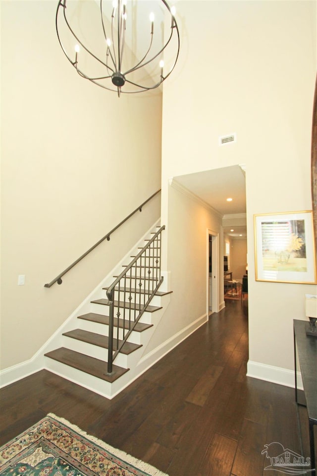 stairs with hardwood / wood-style floors and ornamental molding