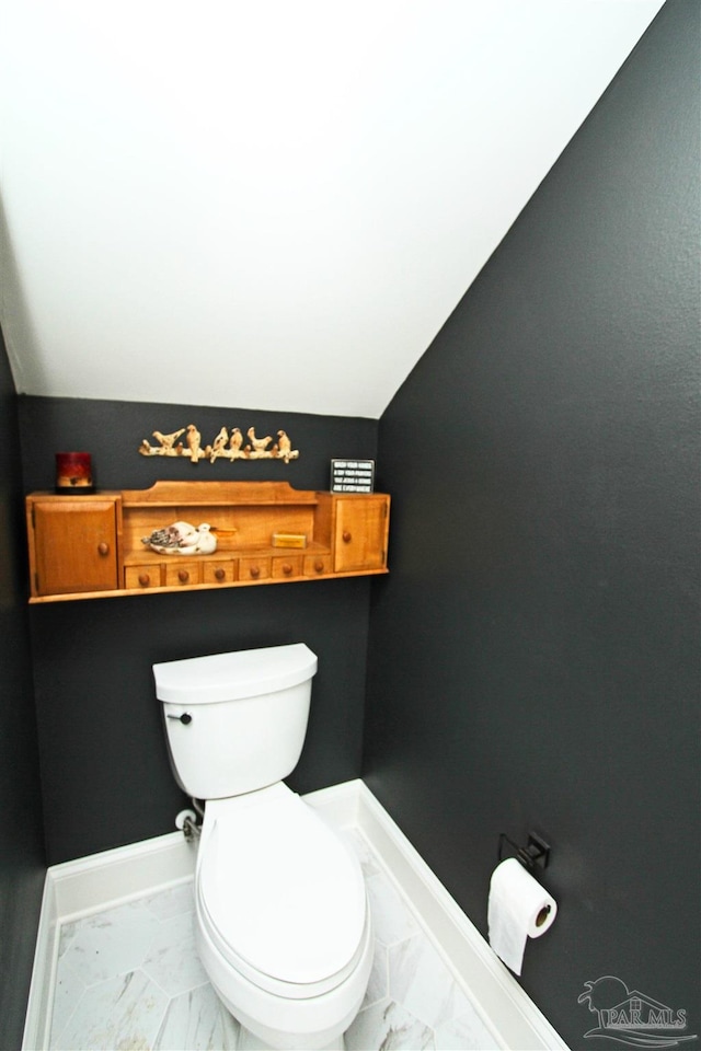 bathroom featuring toilet and lofted ceiling