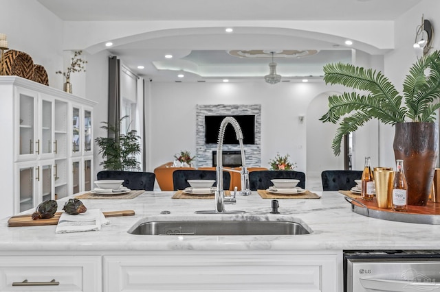 502 Deer Point Dr, Gulf Breeze, FL 32561 - kitchen featuring a sink, arched walkways, light stone counters, dishwashing machine, and recessed lighting