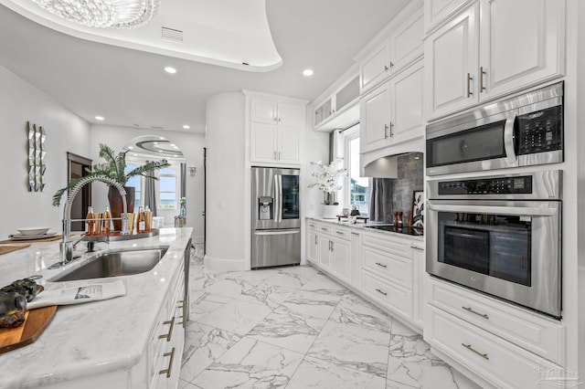502 Deer Point Dr, Gulf Breeze, FL 32561 - kitchen featuring stainless steel appliances, a sink, light marble finish floors, recessed lighting, and white cabinetry