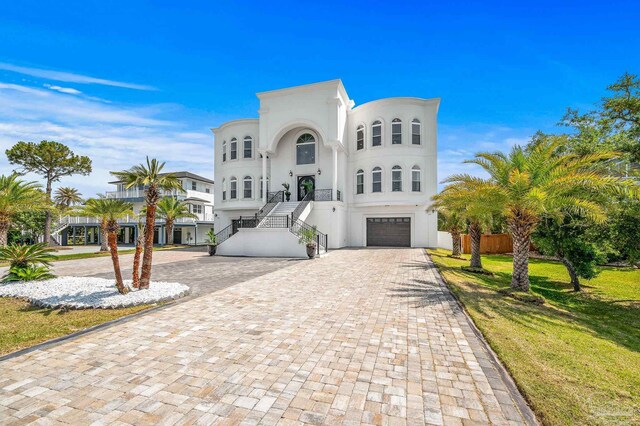 502 Deer Point Dr, Gulf Breeze, FL 32561 - view of front of house with decorative driveway, stairs, a garage, stucco siding, and a front lawn