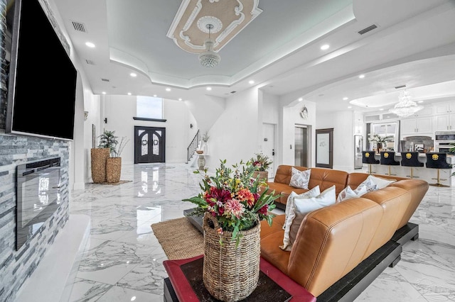 502 Deer Point Dr, Gulf Breeze, FL 32561 - living room featuring a tray ceiling, light marble finish floors, recessed lighting, arched walkways, and a fireplace
