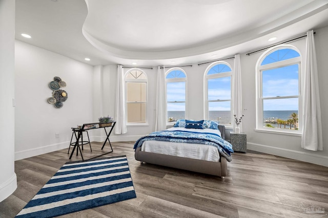 502 Deer Point Dr, Gulf Breeze, FL 32561 - bedroom with recessed lighting, multiple windows, baseboards, wood finished floors, and a water view