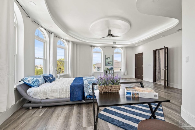 502 Deer Point Dr, Gulf Breeze, FL 32561 - bedroom featuring a raised ceiling, multiple windows, wood finished floors, baseboards, and recessed lighting