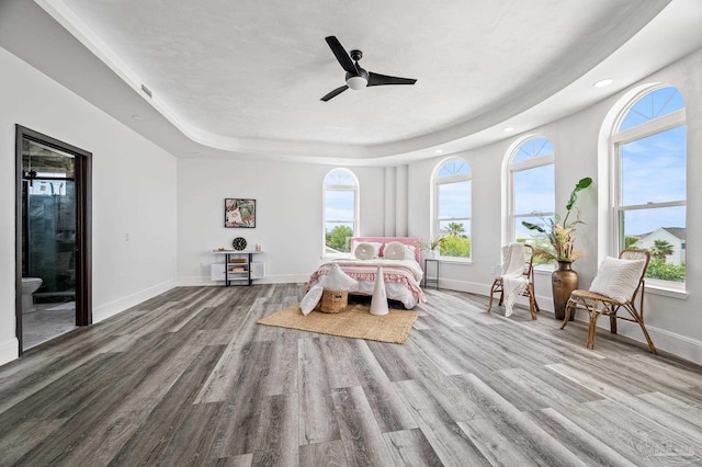 502 Deer Point Dr, Gulf Breeze, FL 32561 - bedroom featuring wood finished floors, a raised ceiling, recessed lighting, baseboards, and connected bathroom