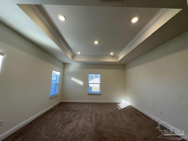 carpeted empty room featuring a raised ceiling and ornamental molding