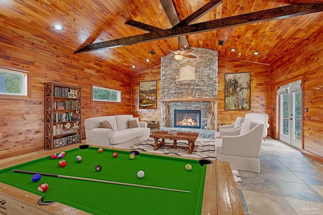 recreation room with a fireplace, french doors, wooden walls, and beamed ceiling