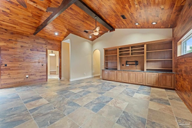 1011 Bucyrus Ln, Cantonment, FL 32533 - unfurnished living room featuring wooden walls, arched walkways, wooden ceiling, ceiling fan, and stone tile flooring