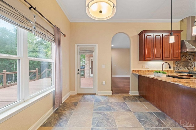 1011 Bucyrus Ln, Cantonment, FL 32533 - kitchen featuring arched walkways, light stone counters, dark stone finish flooring, baseboards, and ornamental molding