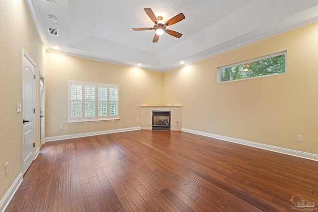 1011 Bucyrus Ln, Cantonment, FL 32533 - unfurnished living room with a tray ceiling, hardwood / wood-style floors, ceiling fan, crown molding, and a tile fireplace