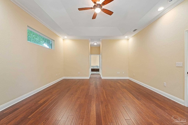 1011 Bucyrus Ln, Cantonment, FL 32533 - empty room featuring a ceiling fan, a raised ceiling, wood-type flooring, crown molding, and baseboards