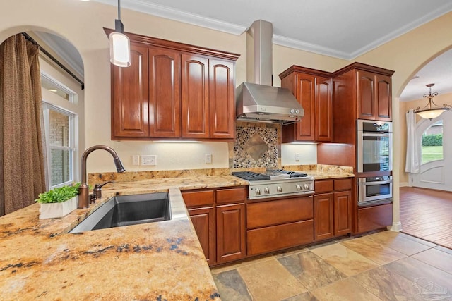 1011 Bucyrus Ln, Cantonment, FL 32533 - kitchen with range hood, appliances with stainless steel finishes, arched walkways, a sink, and pendant lighting