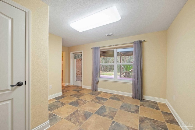 1011 Bucyrus Ln, Cantonment, FL 32533 - unfurnished room featuring stone finish flooring, a textured ceiling, and baseboards