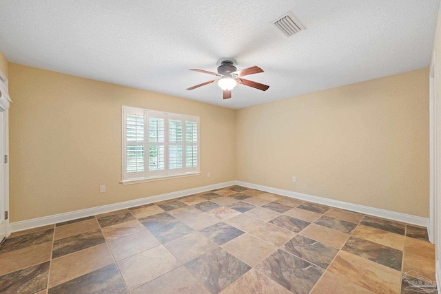 1011 Bucyrus Ln, Cantonment, FL 32533 - spare room featuring a ceiling fan, baseboards, a textured ceiling, and stone finish flooring