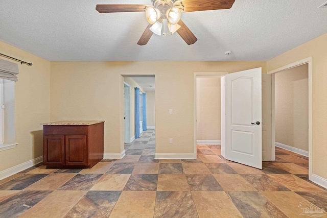 1011 Bucyrus Ln, Cantonment, FL 32533 - unfurnished bedroom with stone finish floors, a textured ceiling, baseboards, and ceiling fan