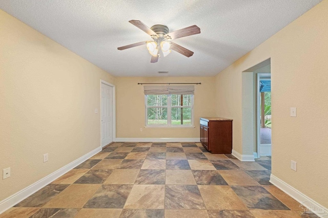 1011 Bucyrus Ln, Cantonment, FL 32533 - unfurnished room featuring ceiling fan, a textured ceiling, baseboards, and stone finish flooring