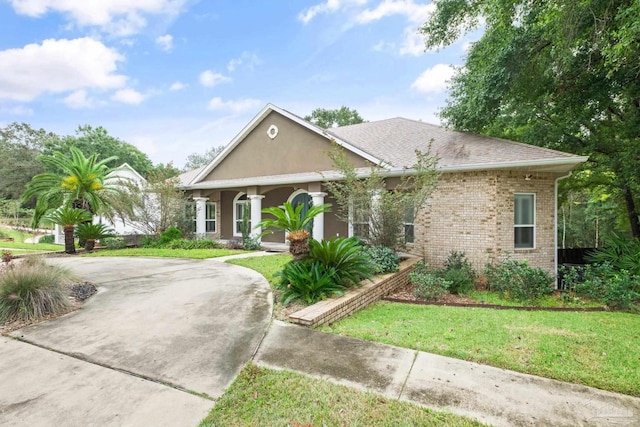 1011 Bucyrus Ln, Cantonment, FL 32533 - view of front of property with a front lawn, curved driveway, brick siding, and a shingled roof