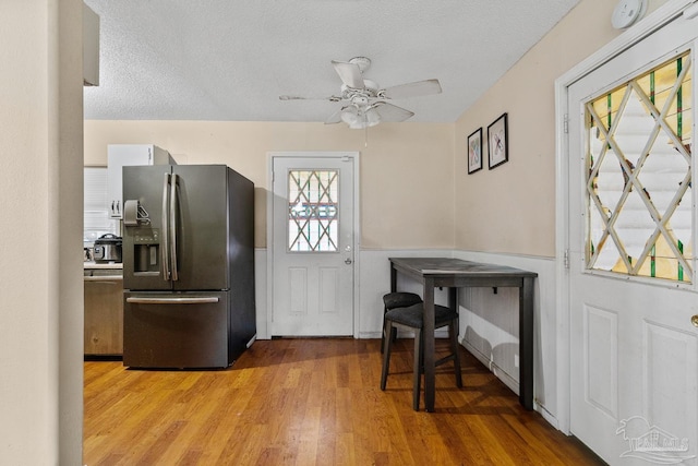 foyer with ceiling fan, light hardwood / wood-style floors, and a textured ceiling