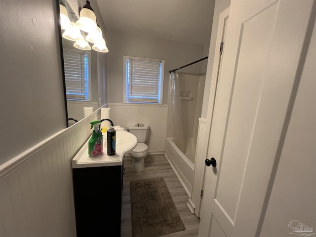 bathroom with vanity, toilet, wood finished floors, and wainscoting