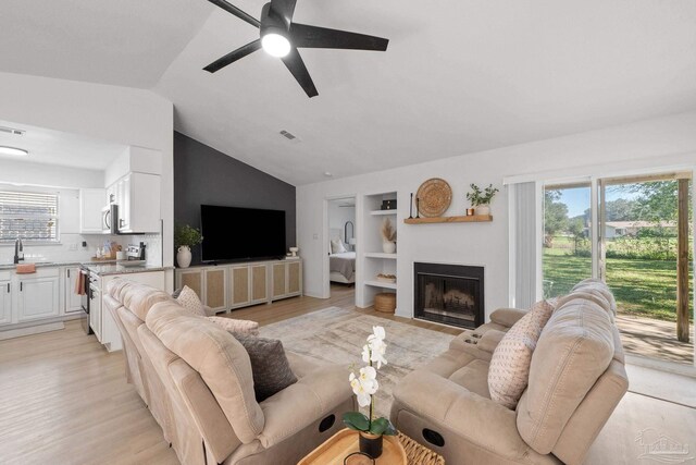 6216 Forest Pines Dr, Pensacola, FL 32526 - living room featuring lofted ceiling, built in shelves, light wood-type flooring, and healthy amount of natural light