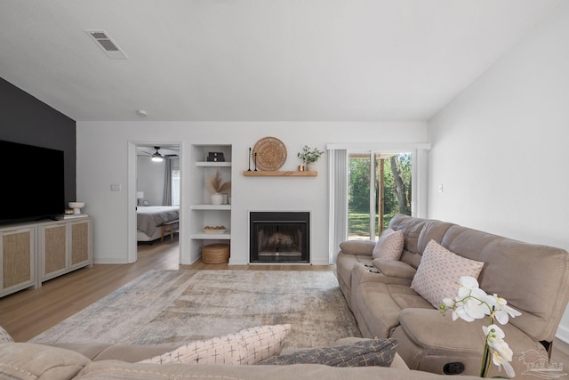 6216 Forest Pines Dr, Pensacola, FL 32526 - living room with wood finished floors, built in features, a fireplace, a ceiling fan, and baseboards