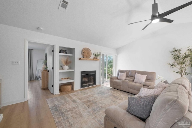 6216 Forest Pines Dr, Pensacola, FL 32526 - living room featuring built in shelves, wood finished floors, ceiling fan, a fireplace, and lofted ceiling